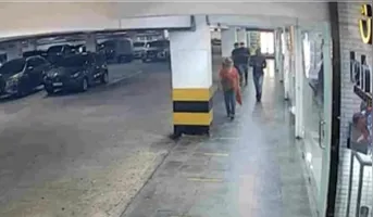 Câmeras de monitoramento mostram os suspeitos perseguindo a vítima (camisa laranja) em estacionamento