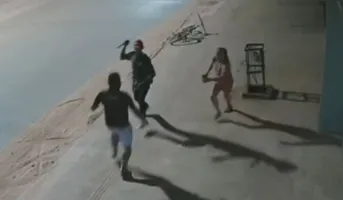 O homem aborda o casal e ameaça a vítima com uma faca para cometer o assalto