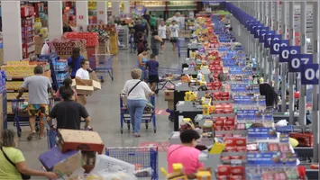 Carrinho de supermercado abastecido com alimentos essenciais. Legenda: Consumo de itens básicos, como arroz e café, registrou alta em todas as regiões do país imediatamente após o bloqueio das plataformas de apostas.