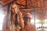 Na gravação, Nana aparece sentada no colo do marido, rindo e dando comida na boca dele.
