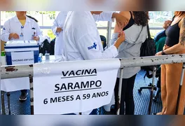 Profissional de saúde aplica vacina contra o sarampo em posto do SUS; imunização gratuita é a única barreira contra a doença.