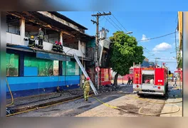 Bombeiros trabalham na operação de rescaldo após o incêndio destruir as estruturas da farmácia UltraPopular e da loja Fill a Fill na Cidade Nova.