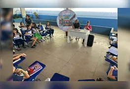 Alunos do 4º ano da Escola Maria Conceição Corrêa conduzem entrevista com a direção no hall da instituição.