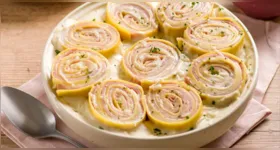 O rondelli de presunto e mussarela ganha molho branco, parmesão e salsinha antes de ir ao forno para gratinar.