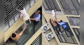 Menina é salva por vizinhos após ficar pendurada no 12º andar de um prédio na China. A rápida mobilização evitou uma tragédia.
