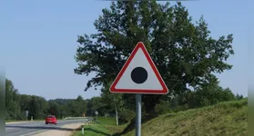 Descubra o que significa a placa triangular com ponto preto no Reino Unido e sua importância na sinalização viária.