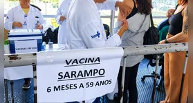 Profissional de saúde aplica vacina contra o sarampo em posto do SUS; imunização gratuita é a única barreira contra a doença.