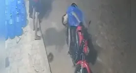 Câmera de segurança registrou o momento em que a mulher arremessa a pedra contra um dos suspeitos durante o assalto.