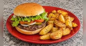 A receita leva carne moída, pão, salada e temperos simples, enquanto as batatas são preparadas com pouco azeite e ficam douradas sem a necessidade de fritura convencional.