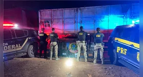 Policiais federais e rodoviários inspecionam fardos de cocaína localizados sob toneladas de milho em bitrem apreendido na BR-155, em Xinguara (PA).