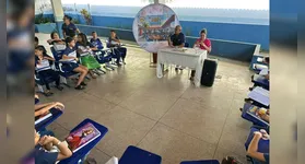 Alunos do 4º ano da Escola Maria Conceição Corrêa conduzem entrevista com a direção no hall da instituição.