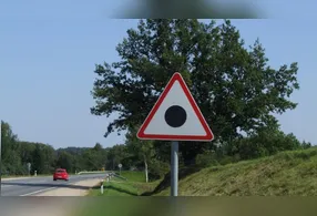 Descubra o que significa a placa triangular com ponto preto no Reino Unido e sua importância na sinalização viária.