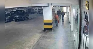 Câmeras de monitoramento mostram os suspeitos perseguindo a vítima (camisa laranja) em estacionamento