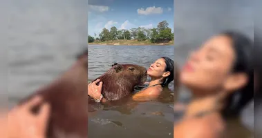 A influenciadora paraense Lia Mendonça viralizou ao compartilhar momentos de carinho com uma capivara, incluindo abraço, mergulho e até um "selinho".