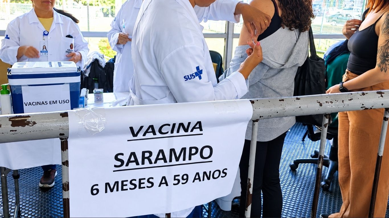 Profissional de saúde aplica vacina contra o sarampo em posto do SUS; imunização gratuita é a única barreira contra a doença.