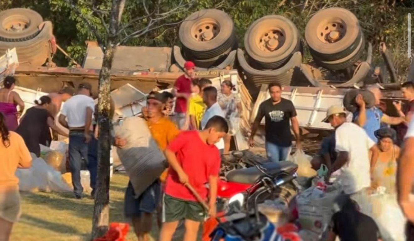 Caminhão tomba e carga que foi esparramada no chão é saqueada por populares