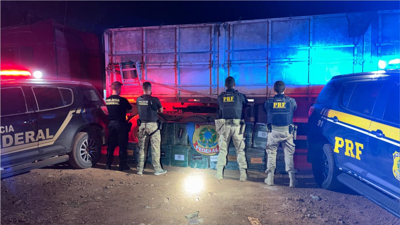 Policiais federais e rodoviários inspecionam fardos de cocaína localizados sob toneladas de milho em bitrem apreendido na BR-155, em Xinguara (PA).