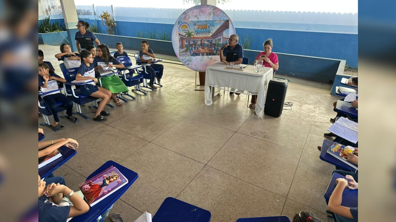 Alunos do 4º ano da Escola Maria Conceição Corrêa conduzem entrevista com a direção no hall da instituição.