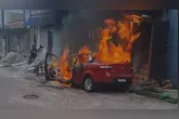 Carro pegando fogo em frente a residência que também é atingida