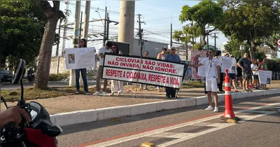Manifestantes exibem faixas e cartazes na Avenida João Paulo II, em Belém, pedindo respeito à ciclofaixa.