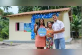 Graciele Sousa dos Anjos, o marido Vamildo Pereira e a filha Camila celebram a conquista da casa própria durante a entrega das moradias do Minha Casa, Minha Vida Rural em Abaetetuba (PA).