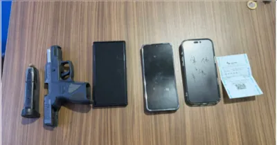 Arma de fogo de uso restrito e celulares apreendidos durante a ação policial que resultou na prisão dos suspeitos.