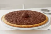 Pizza de brigadeiro combina massa dourada, cobertura cremosa de chocolate, granulado e morangos em uma sobremesa fácil de preparar.
