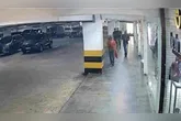 Câmeras de monitoramento mostram os suspeitos perseguindo a vítima (camisa laranja) em estacionamento
