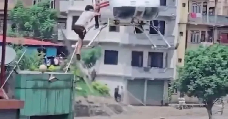 Pessoa é resgatada por helicóptero durante operação de emergência após a forte enchente que atingiu região do Nepal.