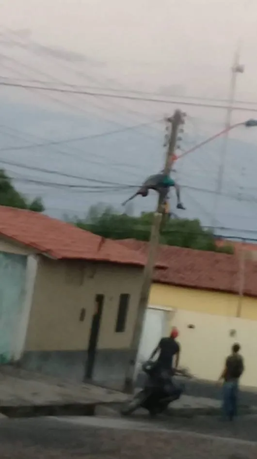 O rapaz desmaia e depois acorda, desce do poste como se nada tivesse acontecido.