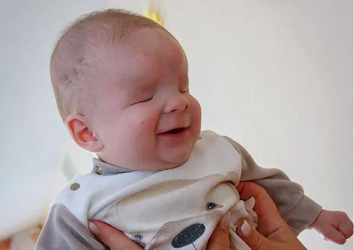 O pequeno é lindo e feliz.