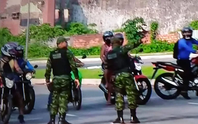 Policiais militares orientam motoristas e motociclistas na via 