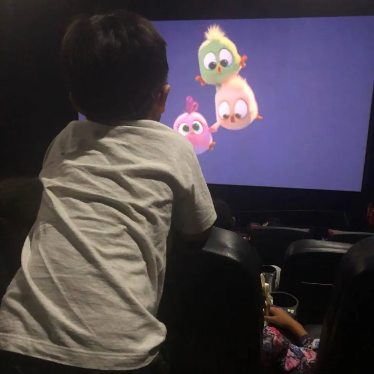 Mateus assistindo o filme Angry Birds em uma sessão azul.