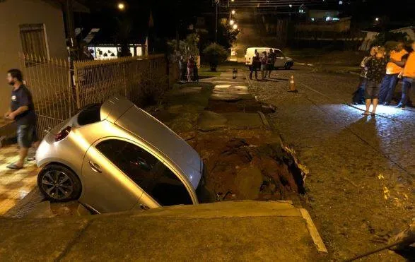 Carro é engolido por cratera na frente da casa do dono