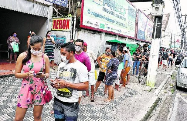 Muita gente foi de madrugada para a frente das agências da Caixa Econômica para garantir os primeiros lugares na fila. Grande procura pelo benefício acabou expondo as pessoas a um risco de contaminação