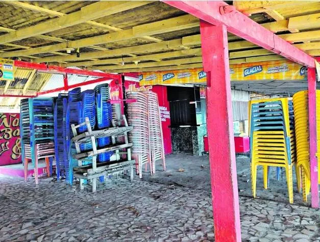 Em Outeiro, mesas e cadeiras empilhadas e sem uso