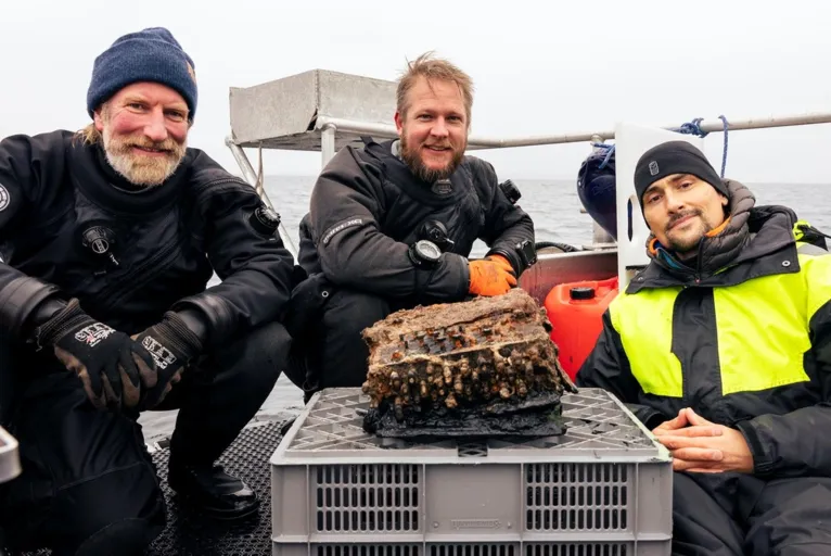 Mergulhaores Christian Howe, Florian Huber e Uli Kunz com equipamento nazista encontrado no mar Báltico