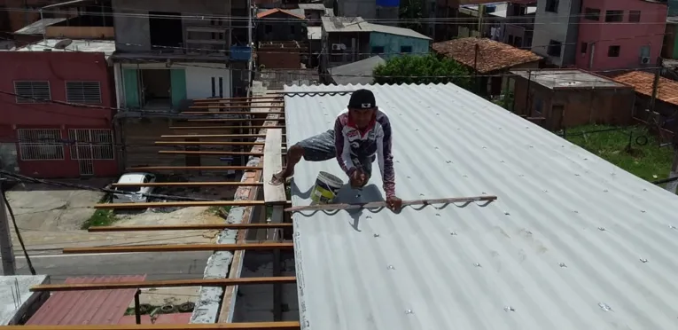 Em cima da casa, profissional faz os retoques necessários 