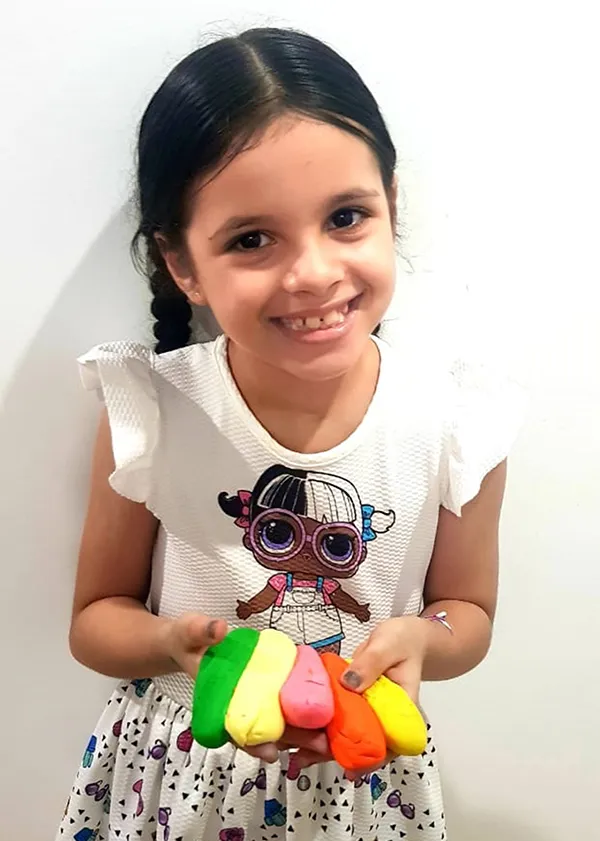 Gabriella Ribeiro, de 7 anos, mostra as massinhas que fez em casa.