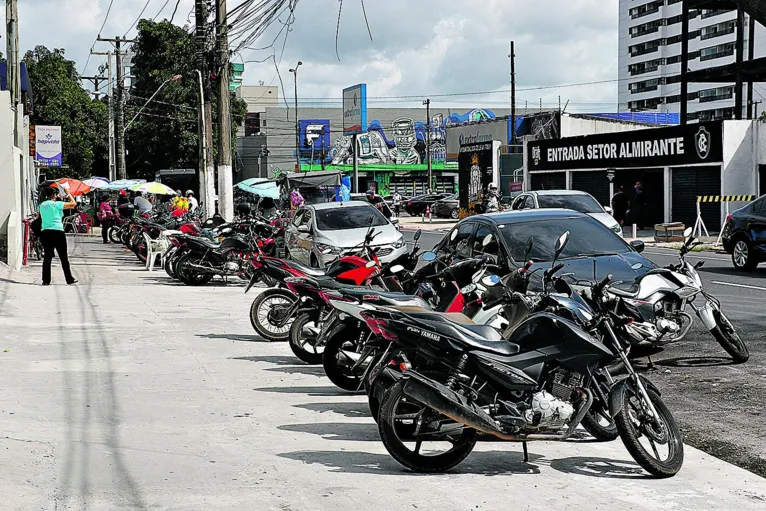 Motoqueiros estacionam nas calçadas.