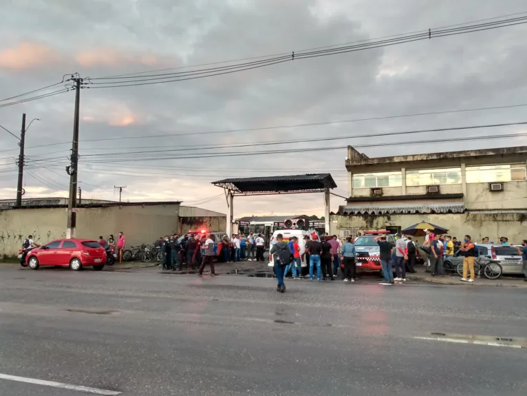 Paradas de ônibus estão cheias de pessoas.