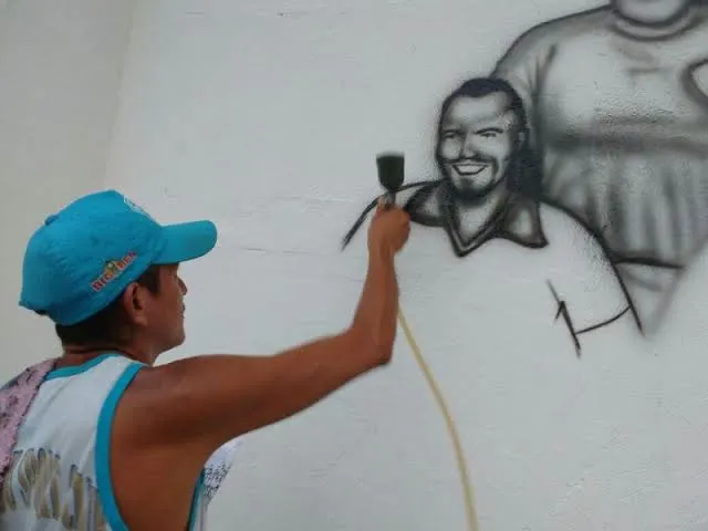 Artista Marcio Kaveira desenhando no muro da Curuzu, o rosto dos atletas que fizeram história com a camisa bicolor