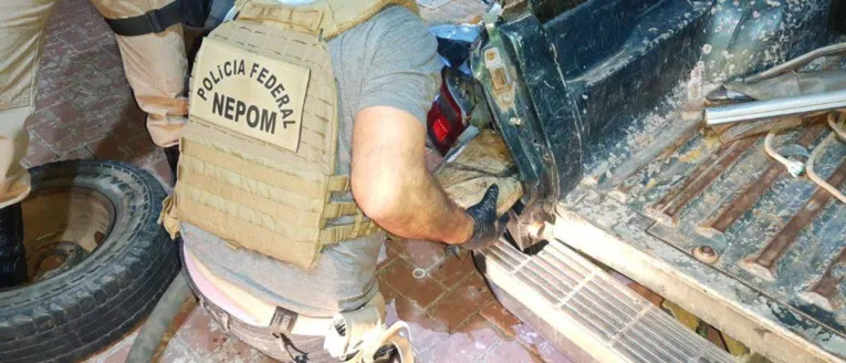 Policiais do GEPOM retirando a droga do compartimento secreto do carro