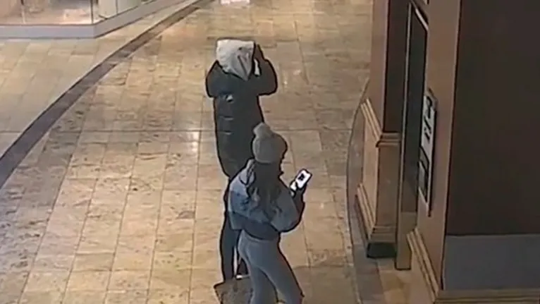 Em vídeo divulgado pela polícia, possível atirador é visto junto de uma mulher entrando no cinema