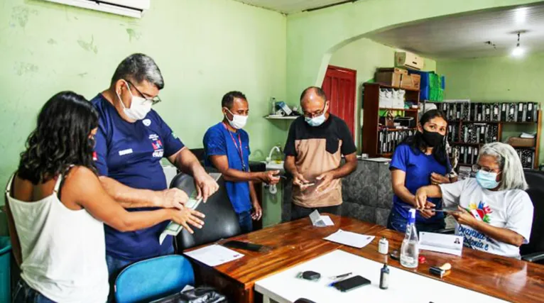 Servidores na coleta das impressões digitais dos moradores interessados na emissão da Carteira de Identidade, em Itupiranga