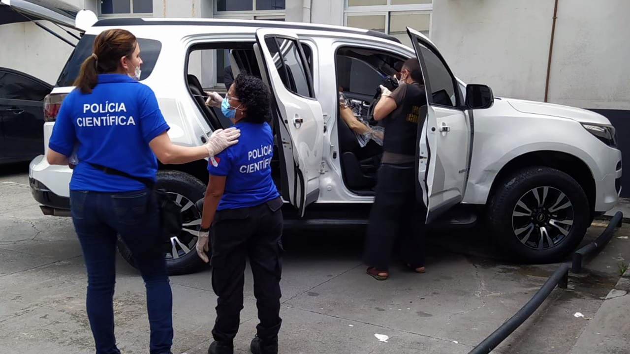 Polícia Científica e policias civis fazem o levantamento no veículo estacionado na DH.