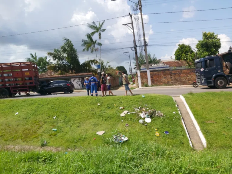 Carro menor com a parte frontal presa na traseira do caminhão.