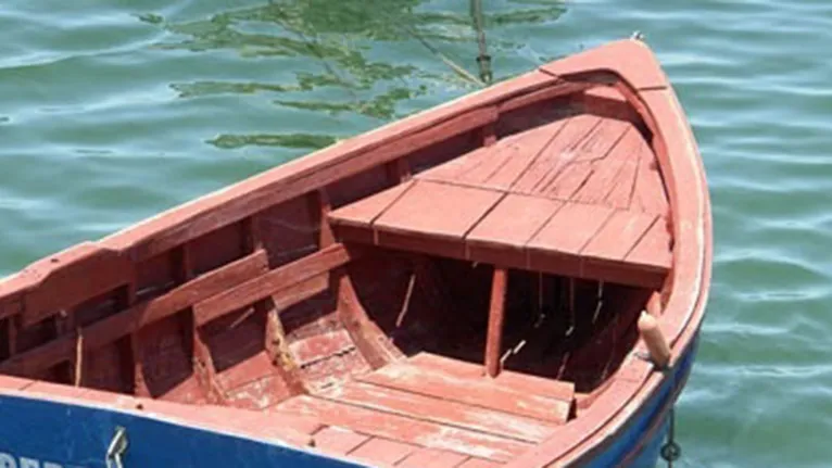 Barco de madeira com casco pintado de vermelho