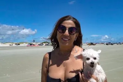 Sandra Santos e seu cachorro aproveitando a faixa de areia sem a circulação de veículos