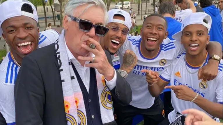 Carlo Ancelotti faz pose com charuto, de óculos escuro, em festa do título do Real Madrid com Vini Jr, Militão, Alaba e Rodrygo.